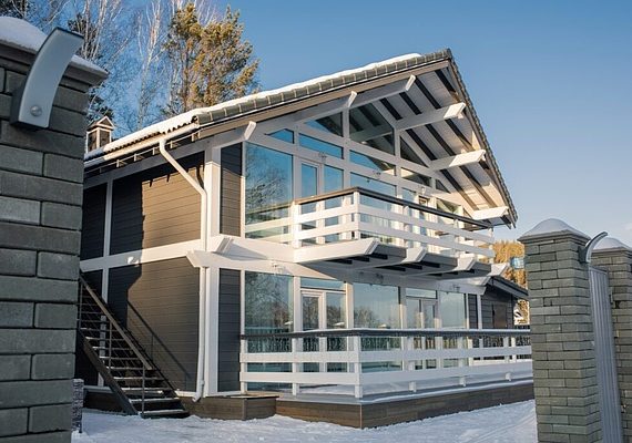 Horizontal no people shot of modern two storey house with large windows, sunny winter day